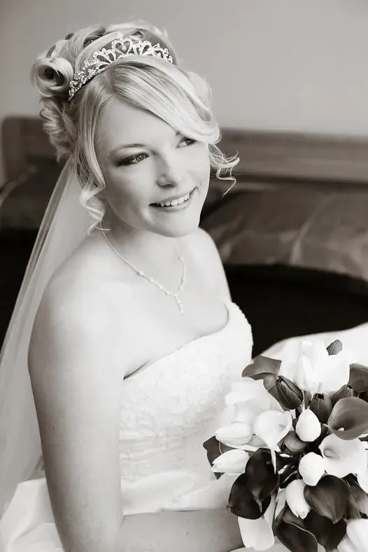 A bride wearing a jewelled tiara and veil with a soft bridal updo
