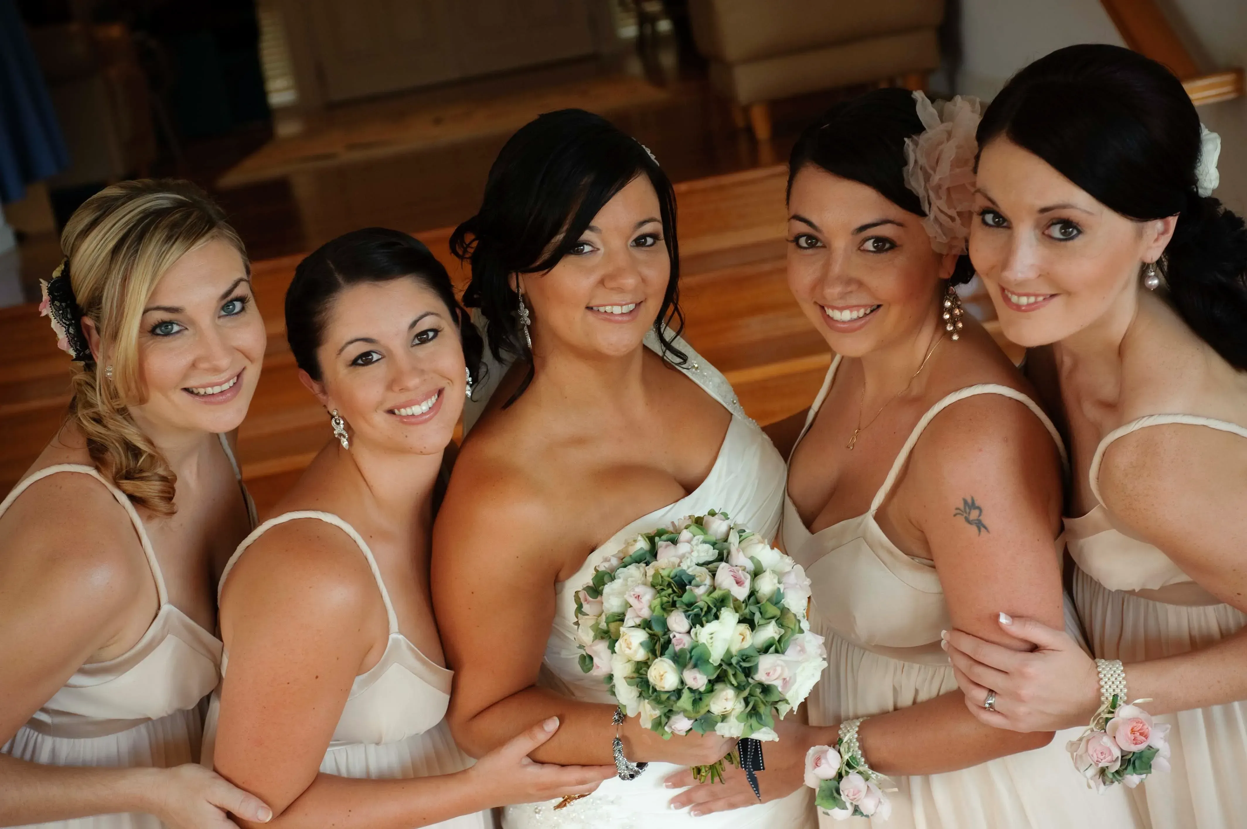 A bride and her bridesmaids together on the wedding morning, hair and makeup finished by Amanda Frost