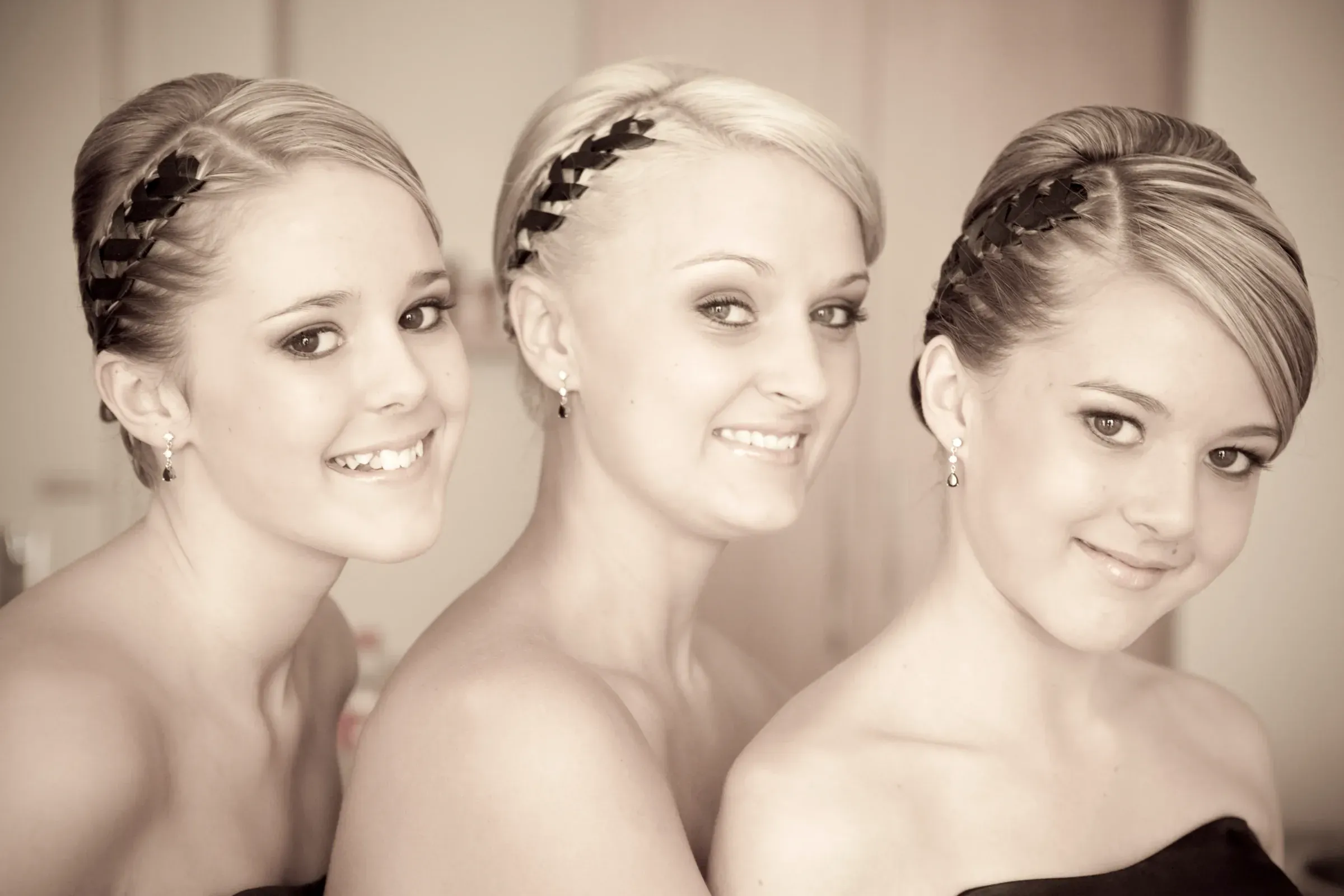 Three bridesmaids in braided halo crowns with soft, natural makeup by Bellus