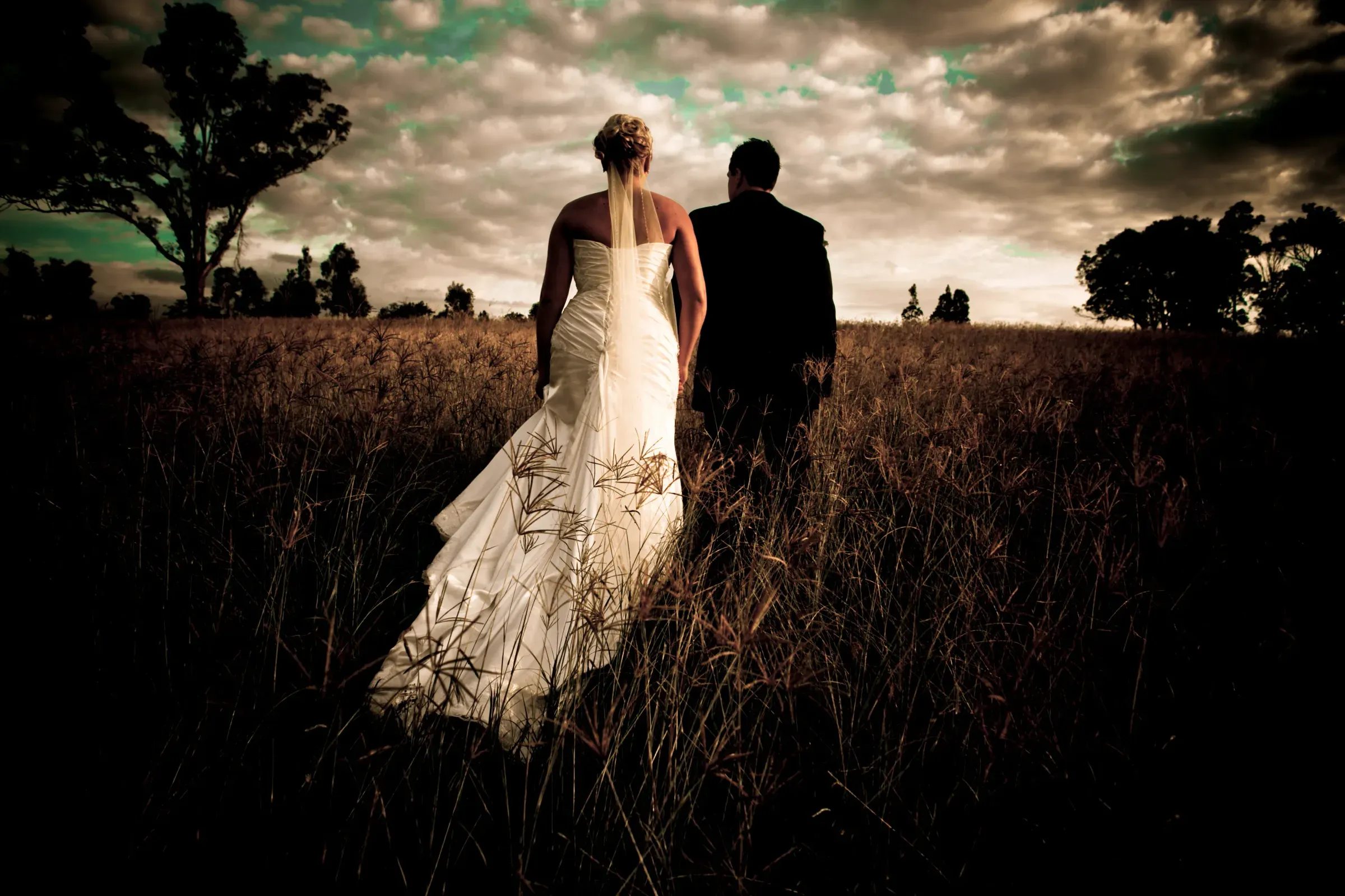 A couple photographed at dusk in an open field after eloping