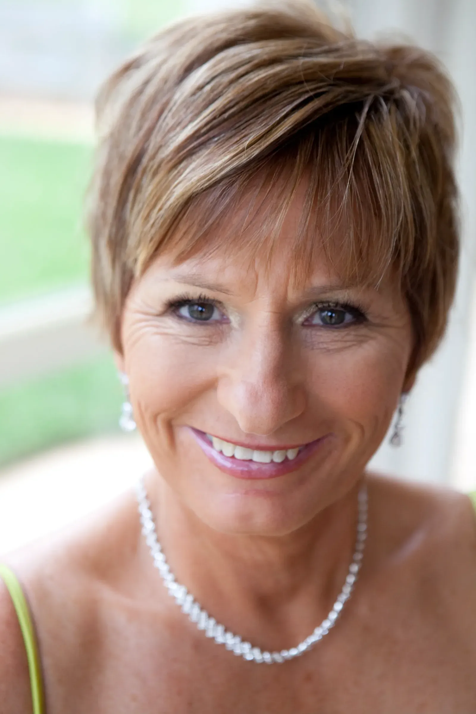 The mother of the bride before the ceremony, her makeup finished in a soft natural tone by Amanda Frost