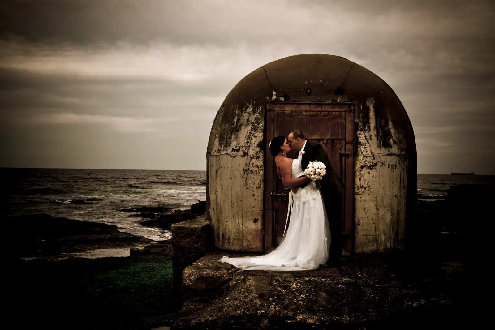 A couple photographed by the sea after their elopement ceremony