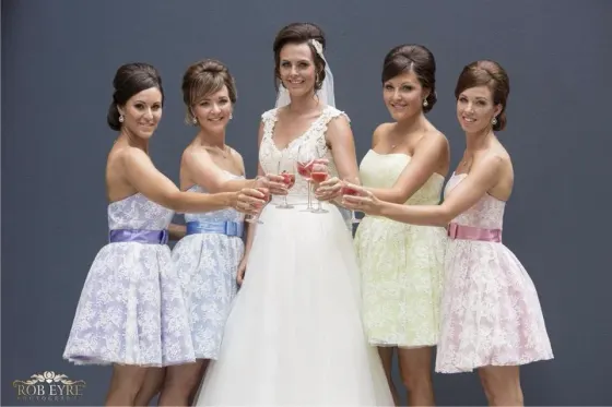 Bridal party hair and makeup, the bridesmaids raising a glass to the bride